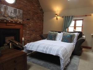 ナントウィッチにあるPillory House Loft Apartmentのベッドと暖炉のある寝室