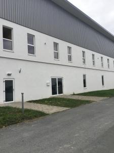 a large white building with doors and windows at Stundenhotel Krieger in Büren