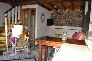 een woonkamer met een houten tafel en een stoel bij Casa do Conto in Doade