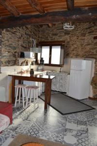 een keuken met een tafel en een koelkast bij Casa do Conto in Doade