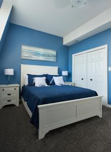 a blue bedroom with a large bed with blue walls at Vine Village in Niagara-on-the-Lake