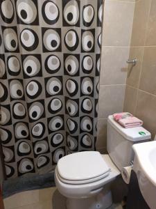 a bathroom with a toilet and a black and white shower curtain at Magallanes in Ushuaia