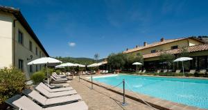 a swimming pool with lounge chairs and umbrellas next to a building at Relais dell'Olmo in Perugia