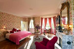 a bedroom with a bed with pink sheets and flowers at Chateau le Quesnoy in Chevrières