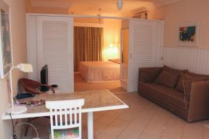 a living room with a couch and a bed at Vitória Hotel Residence NewPort in Campinas