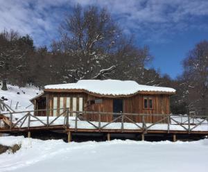 a wooden cabin with snow on top of it at KuyKuy Lodge in Malalcahuello