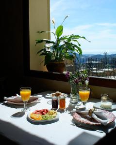 a table with breakfast foods and orange juice on it at Cases Noves - Boutique Accommodation - Adults Only in Guadalest