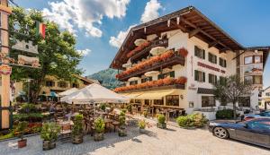 a hotel with tables and chairs in front of a building at Ruhpoldinger Hof in Ruhpolding