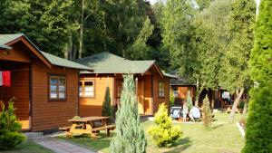 eine Blockhütte mit einem Picknicktisch im Hof in der Unterkunft Camping Baltic in Kołobrzeg