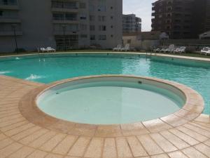 une grande piscine d'eau bleue dans un bâtiment dans l'établissement Departamento Serena Pacífico, à La Serena