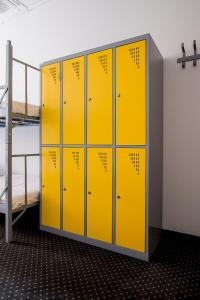 a locker room with yellow lockers and a bunk bed at Inbed Hostel in Warsaw