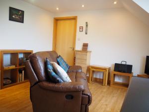 a living room with a brown leather couch at Decca - Self Catering Shetland in Lerwick