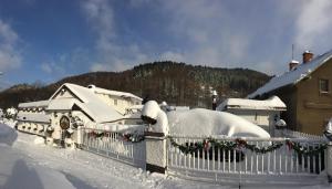 a house covered in snow with christmas decorations at Penzion OK in Svoboda nad Úpou
