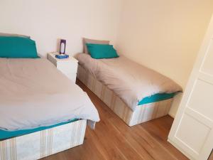 two twin beds in a small room with wooden floors at The Bungalow in London