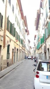 un'auto bianca parcheggiata in una strada con edifici di i' David a Firenze