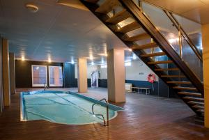 Una gran piscina en una habitación con escalera. en Miramar Ski a pie de pista, en Sierra Nevada
