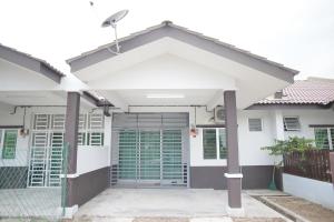 a white house with a gate and a garage at Arau Idaman Homestay in Arau