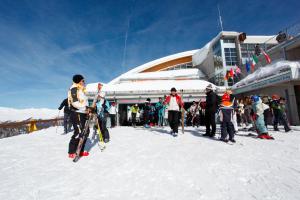 a group of people standing in the snow in front of a building at Hotel Michela in Malè