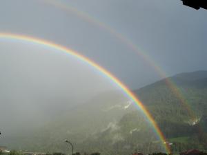 Ein Regenbogen über einem Berg in der Unterkunft Hotel Michela in Malè