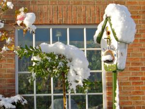 a snow covered bird house in front of a window at Hotel Am Steendamm in Oyten