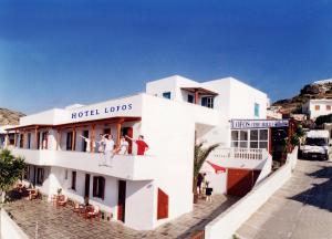 - un bâtiment avec des personnes sur le balcon d'un hôtel dans l'établissement Hotel Lofos - The Hill, à Ios Chora