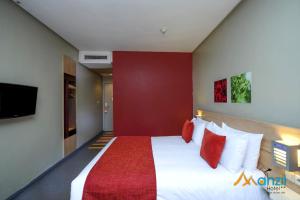 A bed or beds in a room at Manzil Hotel