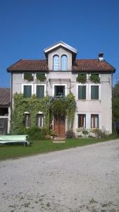 a large white house with a bench in front of it at B&b Col del Vin in Belluno