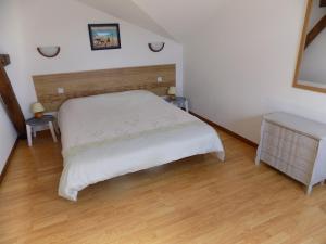 1 dormitorio con 1 cama blanca y 2 mesas en Logis Gascons Gite 1, en Saint-Justin