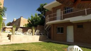 a group of white chairs sitting outside of a building at Dormi's - Adult's Only in Mina Clavero