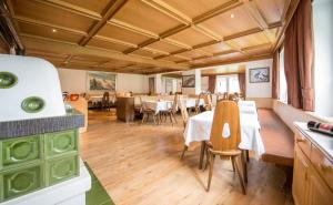 a restaurant with tables and chairs in a room at Alpin Garni die kleine Post in Solda