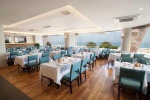 a dining room with white tables and blue chairs at PortoBay Rio de Janeiro in Rio de Janeiro