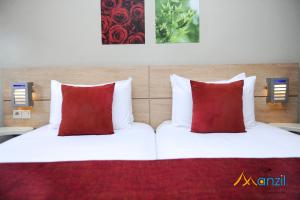 A bed or beds in a room at Manzil Hotel
