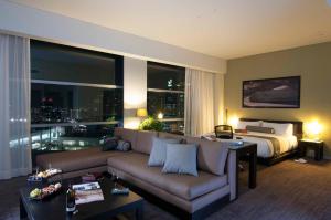 a living room with a couch and a bed at Stadia Suites Mexico City Santa Fe in Mexico City
