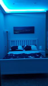 Schlafzimmer mit einem Bett mit blauem Licht in der Unterkunft Ilemony in Neapel