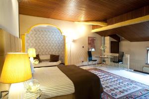 sypialnia z łóżkiem z lampką i kanapą w obiekcie Relais Del Castello Di Oviglio w mieście Oviglio +37 zdjęć