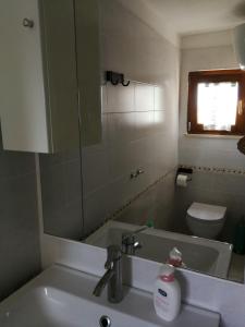 a bathroom with a sink and a mirror and a toilet at B&B Le Volte in Sarno