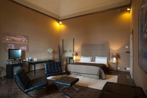 a bedroom with a bed and a desk and a television at Relais Del Castello Di Oviglio in Oviglio