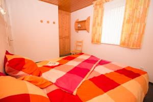 ein Schlafzimmer mit einer bunten Bettdecke auf einem Bett in der Unterkunft Wangeroogeweg 5a in Schillig