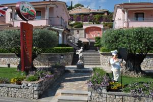 een persoon die in een tuin voor een gebouw staat bij Hotel Ristorante Borgo La Tana in Maratea