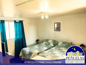 a bedroom with a bed and a window at Apart Hotel Penuelas in Coquimbo