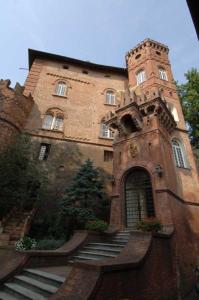 duży ceglany budynek ze schodami prowadzącymi do niego w obiekcie Relais Del Castello Di Oviglio w mieście Oviglio