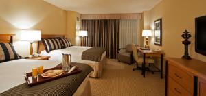 a hotel room with two beds and a desk at Hollywood Casino Gulf Coast in Bay Saint Louis