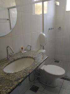 a bathroom with a sink and a toilet at Hotel Pinheiros in Chonim de Baixo