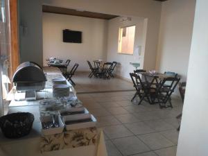 a kitchen with chairs and a counter with a stove at Hotel Pinheiros in Chonim de Baixo