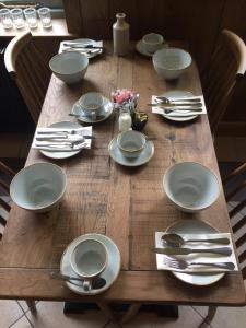 a wooden table with plates and silverware on it at Victoria Inn in Llanbedr