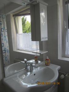 a bathroom with a sink and a mirror and a tub at Am Rasthof Dresdner Tor in Wilsdruff