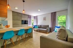 a living room with a couch and a table and chairs at Apartamenty Nautica blisko plaży in Niechorze