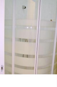 una puerta de ducha de cristal con reflejo de una escalera en Hostal Casa 18 en Madrid