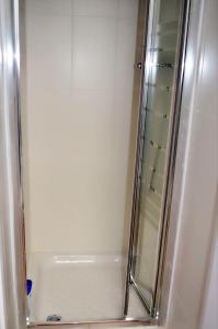 y baño con ducha y puerta de cristal. en Hostal Casa 18 en Madrid