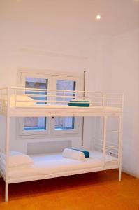 Litera blanca en habitación con ventana en Hostal Casa 18, en Madrid